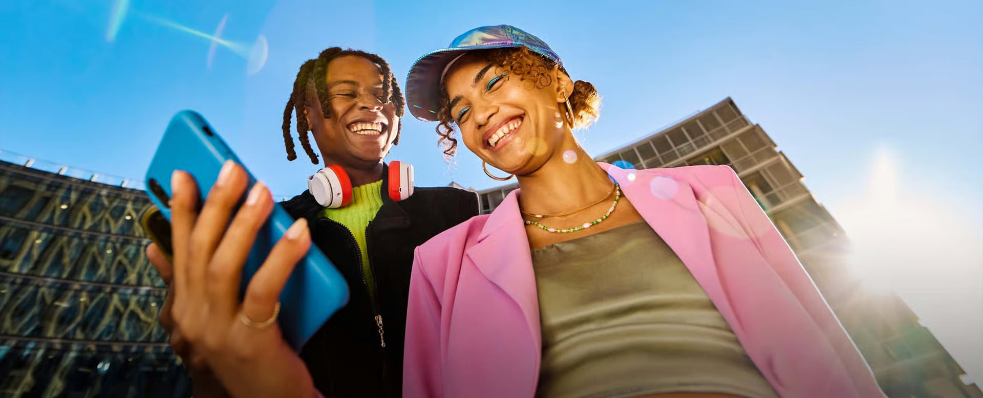 Two people taking a selfie outdoors with a clear blue sky.